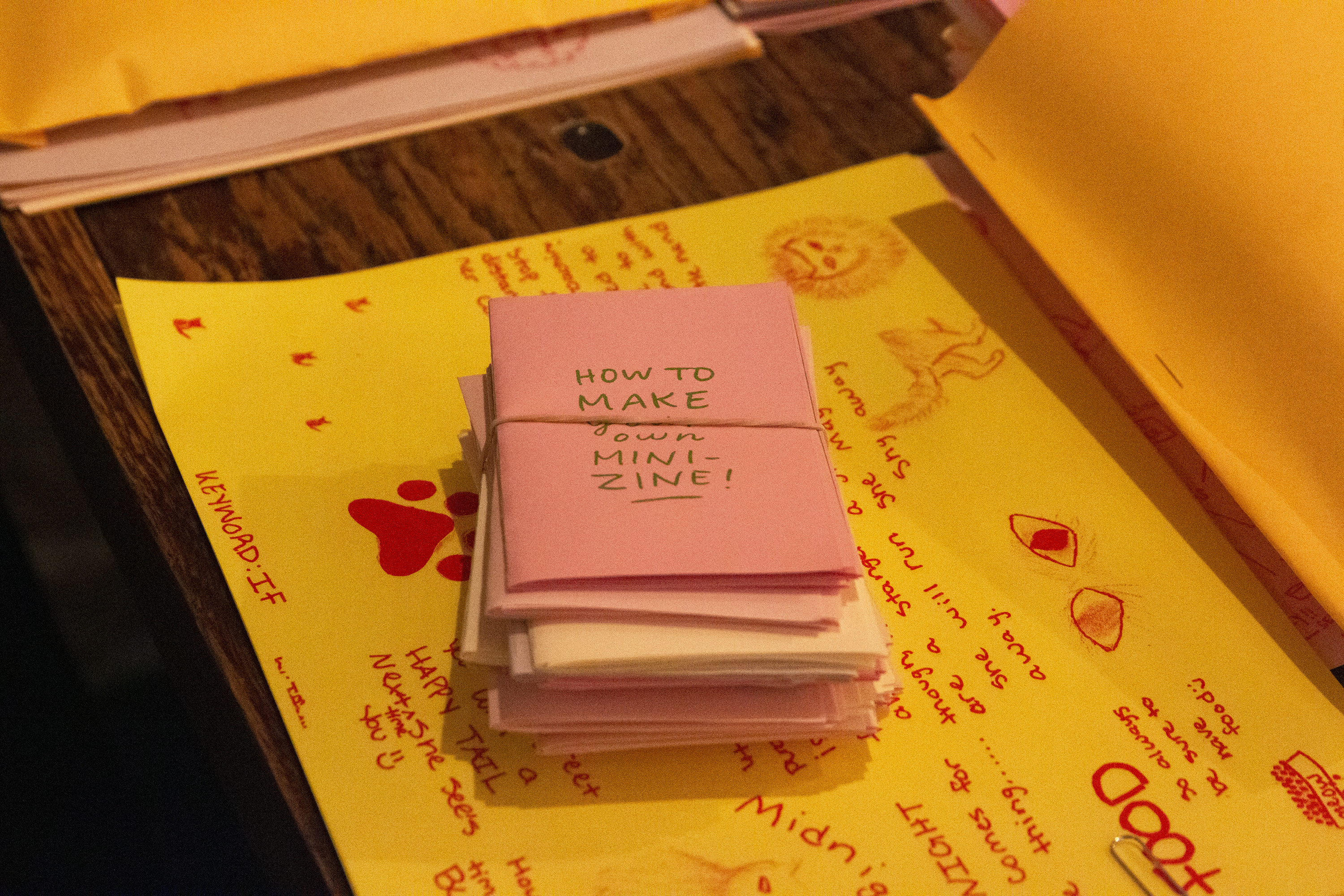 A stack of zines, the top reading "How to Make Your Own Zine"